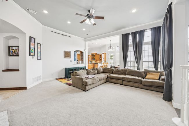 Living area featuring arched walkways, light colored carpet, a ceiling fan, recessed lighting, and crown molding | Image 4