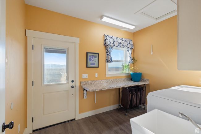 Clothes washing area with dark wood-type flooring, a sink, baseboards, washer / dryer, and laundry area | Image 25