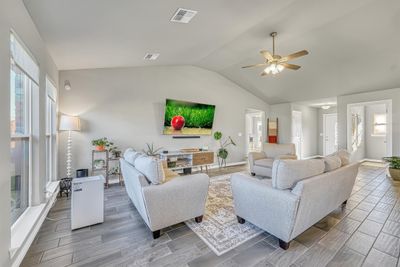 Living room with lofted ceiling, a wealth of natural light, and hardwood / wood-style floors | Image 3