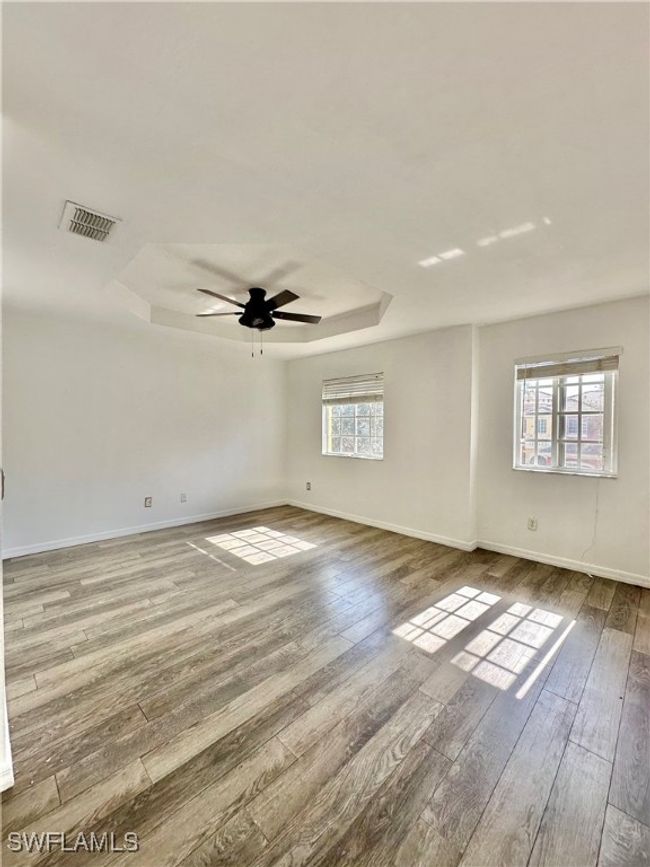Unfurnished room with a tray ceiling, ceiling fan, and hardwood / wood-style flooring | Image 14