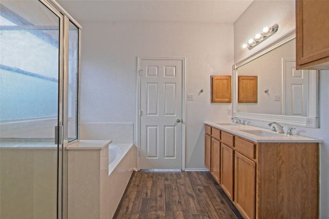 Full bathroom with wood finished floors, a bath, double vanity, and a shower with door | Image 18