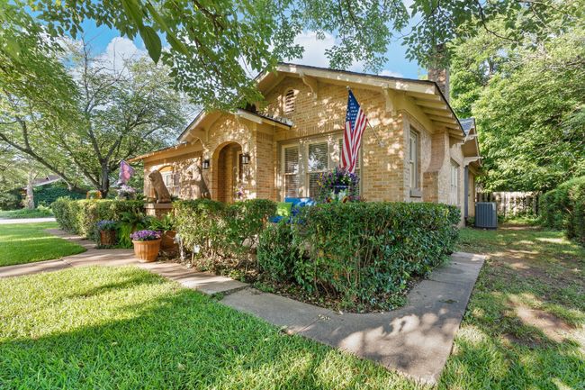 View of front facade featuring brick siding, cooling unit, a chimney, and a front lawn | Image 6