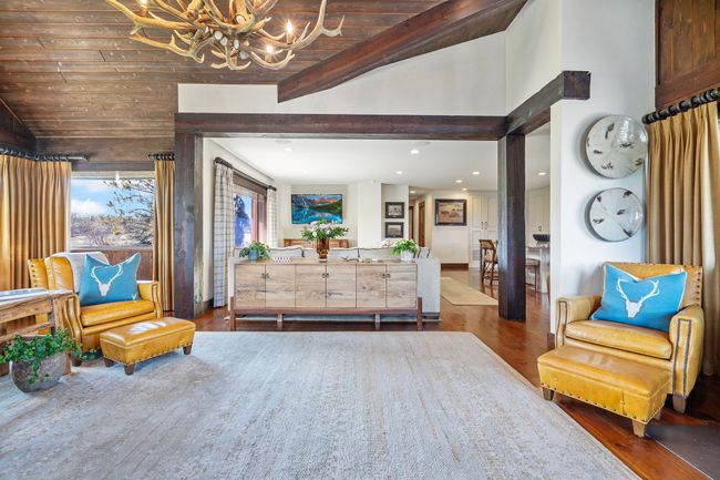 Sitting area at Entrance of home. Featuring recessed lighting, an inviting chandelier, wood finished floors & Fireplace. | Image 13