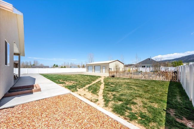 View of yard with a garage, a fenced backyard, and an outdoor structure | Image 61
