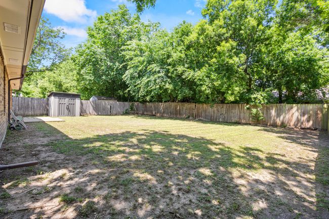 View of yard with a storage unit and an outdoor structure | Image 23