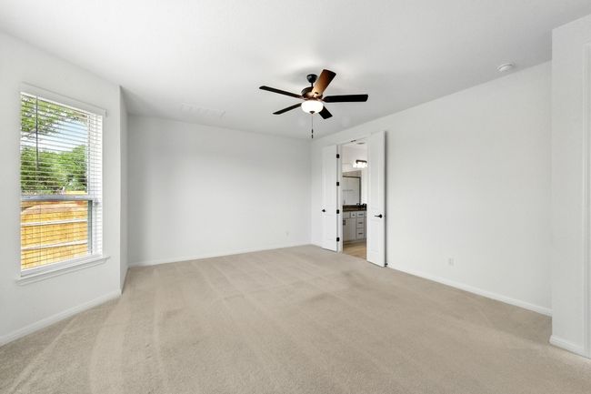 Empty room with light colored carpet, a ceiling fan, and baseboards | Image 17