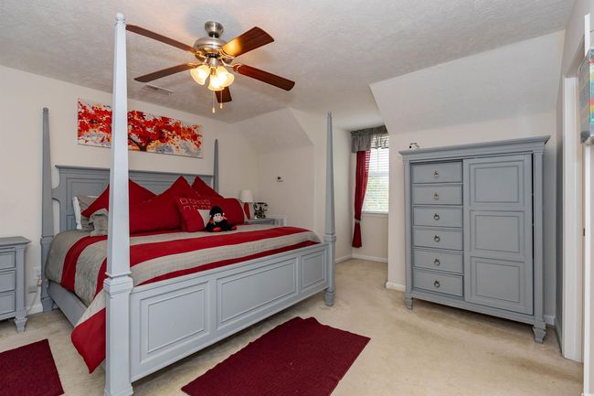 Bedroom with light carpet, a textured ceiling, baseboards, visible vents, and ceiling fan | Image 17