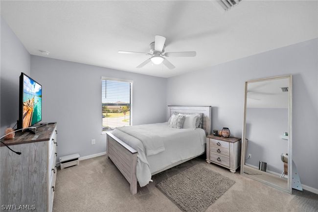 Bedroom featuring light carpet and ceiling fan | Image 32