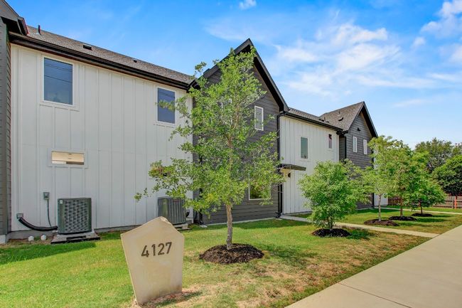 View of side of property featuring board and batten siding, cooling unit, and a lawn | Image 32