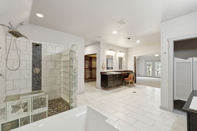 Bathroom featuring french doors, tile patterned flooring, vanity, and a tile shower | Image 27