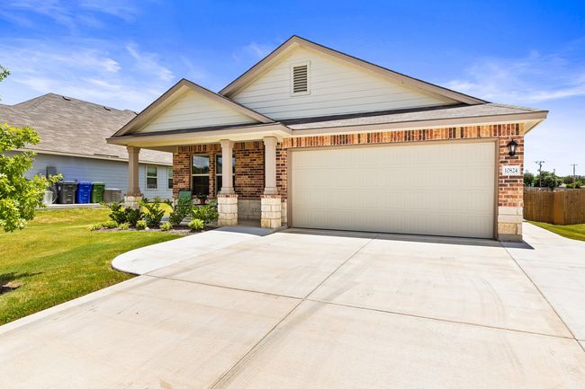 View of front of house with brick siding, concrete driveway, an attached garage, and a porch | Image 5