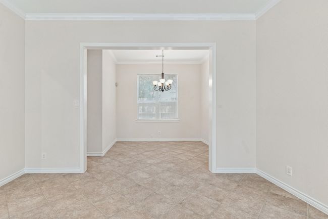 Unfurnished room featuring a chandelier and ornamental molding | Image 9