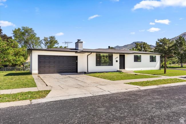 Ranch-style home featuring a garage, a front lawn, a chimney, and driveway | Image 42