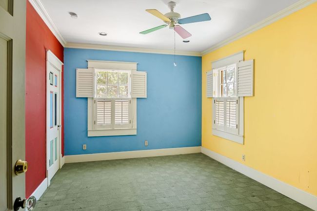 Carpeted empty room with crown molding, ceiling fan, and a smoke detector | Image 17
