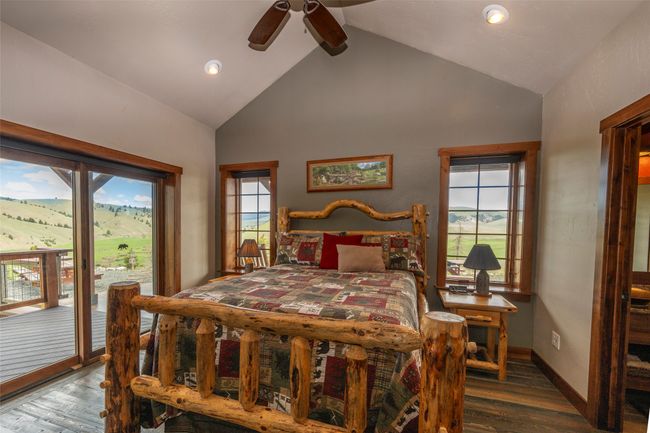 Bedroom with access to exterior, wood finished floors, high vaulted ceiling, recessed lighting, and baseboards | Image 18