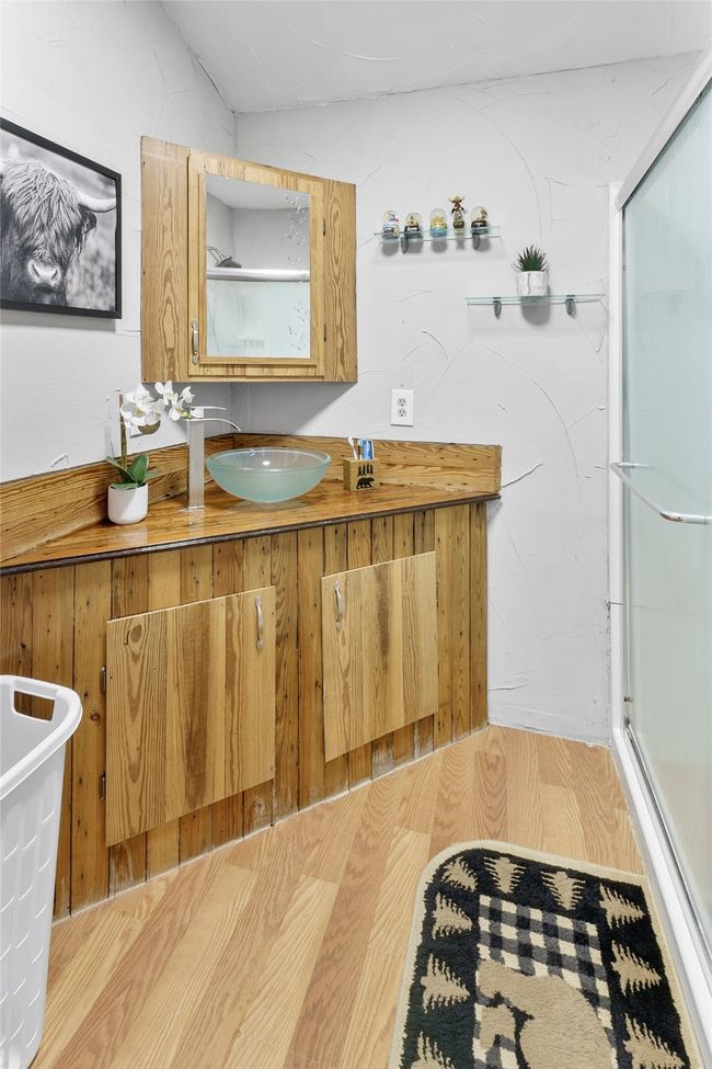 Full bathroom featuring a shower with door, vanity, and wood finished floors | Image 10