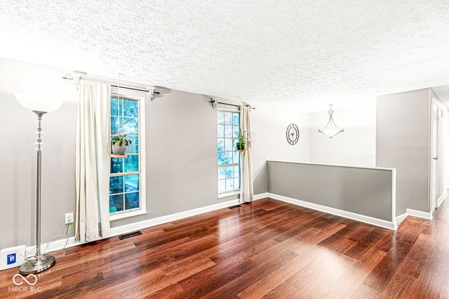 empty room with wood finished floors, a textured ceiling, and plenty of natural light | Image 9