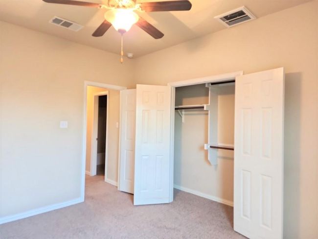 Unfurnished bedroom featuring a closet, light carpet, baseboards, and a ceiling fan | Image 15