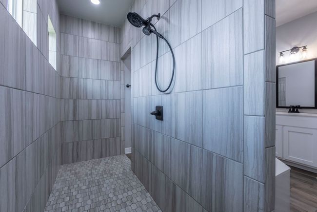 Bathroom with a tile shower, vanity, recessed lighting, and tile walls | Image 16