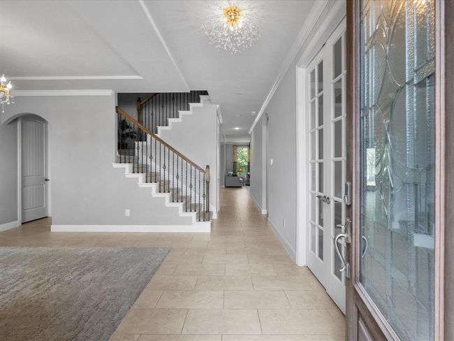 This spacious two-story home features a charming stone and brick facade, a well-maintained front yard with landscaped garden beds, and a two-car garage. Located in a serene neighborhood, it offers a welcoming driveway and abundant natural light. | Image 5