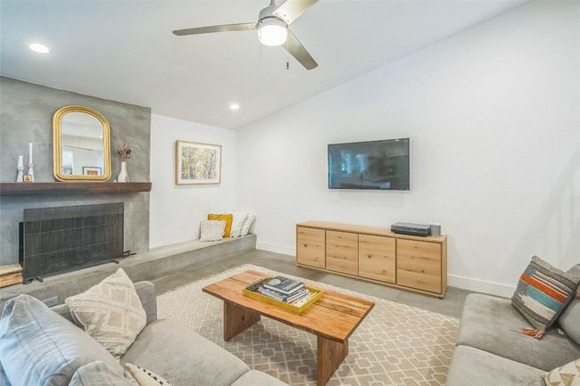 Living room with lofted ceiling, ceiling fan, a fireplace, and recessed lighting. | Image 11