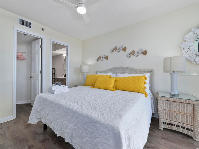 Bedroom featuring wood finished floors, visible vents, baseboards, ceiling fan, and a walk in closet | Image 24