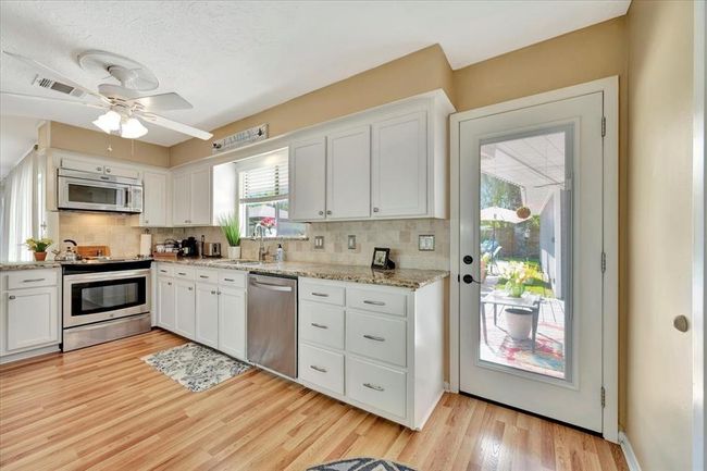The kitchen offers stainless appliances, lots of counter space, a backdoor just out to the pool area and garage. | Image 18