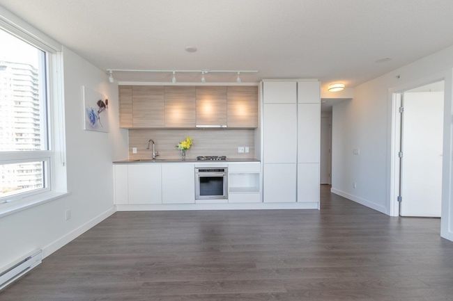 Kitchen with appliances with stainless steel finishes, baseboard heating, a sink, and modern cabinets | Image 4