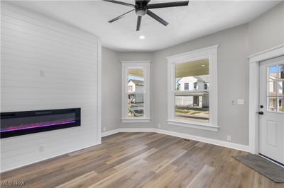 Unfurnished living room with a fireplace, light hardwood / wood-style floors, and ceiling fan | Image 2