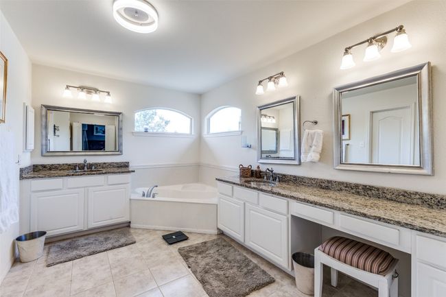 Bathroom with two vanities, a garden tub, and tile patterned floors | Image 15
