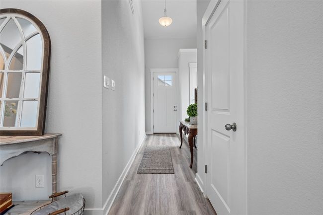Hallway featuring wood finished floors and baseboards | Image 6