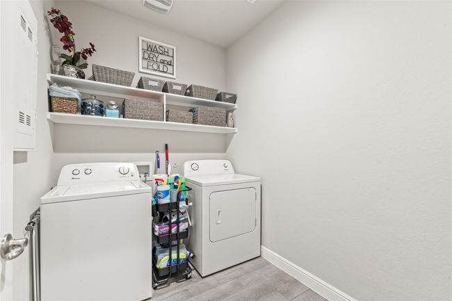 Clothes washing area with washer and dryer, baseboards, laundry area, and light wood finished floors | Image 25