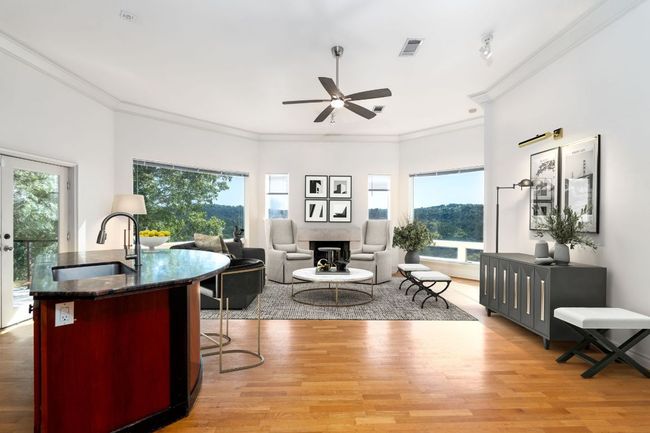Living room featuring ornamental molding, large windows and light wood finished floors. | Image 6