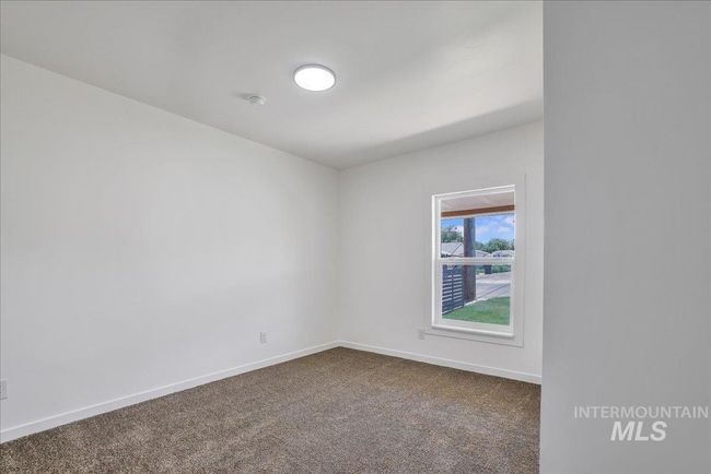 Spare room featuring dark colored carpet and baseboards | Image 22