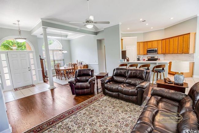 Living room featuring decorative columns, light wood-type flooring, ornamental molding, ceiling fan, and recessed lighting | Image 10