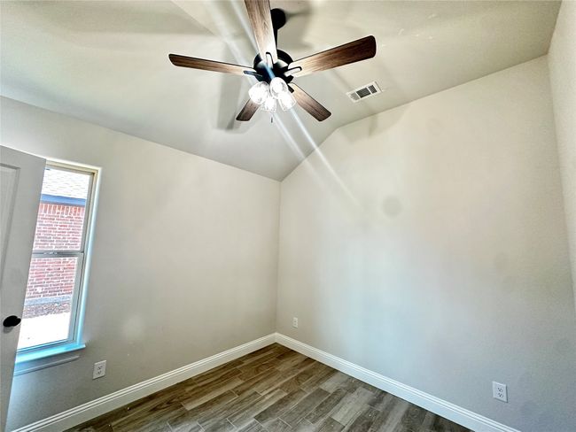 Empty room with dark wood finished floors, a ceiling fan, baseboards, and lofted ceiling | Image 20