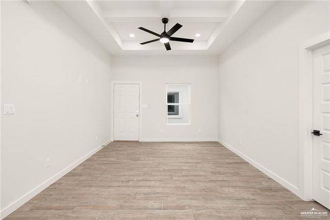 Unfurnished room featuring coffered ceiling, recessed lighting, a ceiling fan, light wood-style floors, and beam ceiling | Image 13