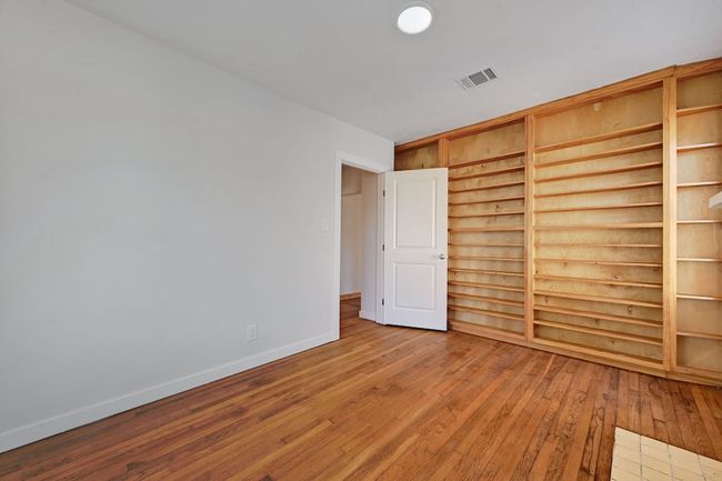Unfurnished bedroom featuring visible vents, baseboards, and wood-type flooring | Image 11
