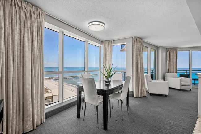Dining area featuring a textured ceiling, carpet flooring, and a water view | Image 11