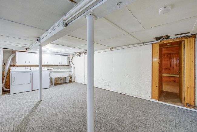 Unfinished below grade area with washer and clothes dryer and carpet flooring | Image 40