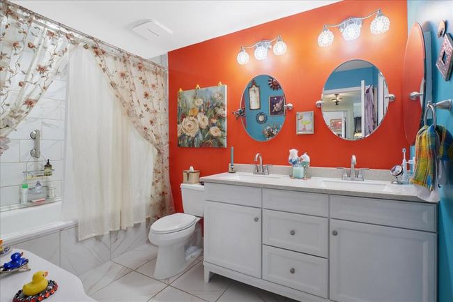 Bathroom with shower / tub combo with curtain, double vanity, and toilet | Image 11