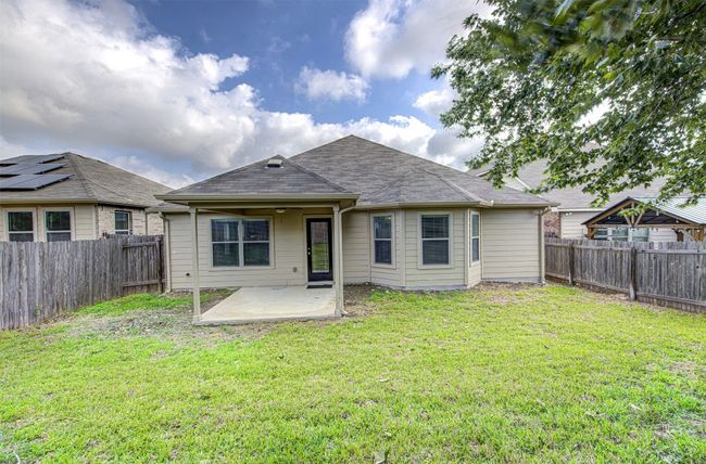Rear view of property with a patio area, a fenced backyard, and a shingled roof | Image 25