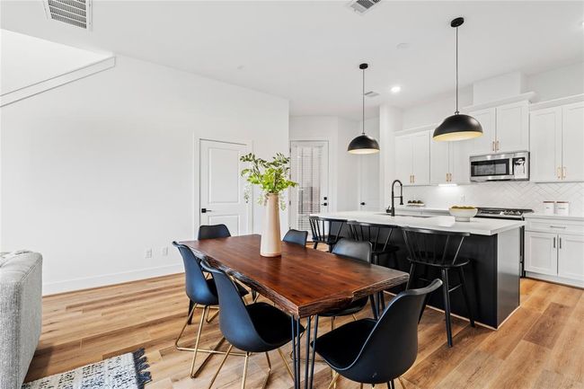 The spacious dining area, adjacent to a chef’s kitchen with a large island, provides the perfect setting for hosting family and friends in style. | Image 7