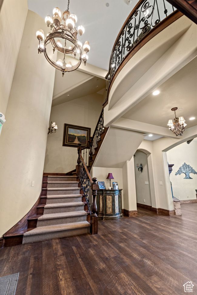 Staircase featuring arched walkways, recessed lighting, wood finished floors, a notable chandelier, and baseboards | Image 16