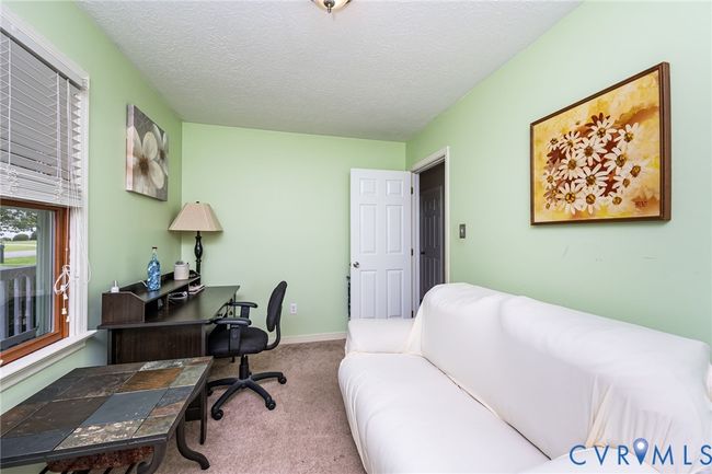 Carpeted office with a textured ceiling and baseboards | Image 14