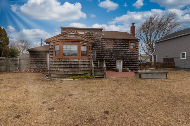 View of front of property featuring a chimney, fence, a front lawn, and roof with shingles | Image 5