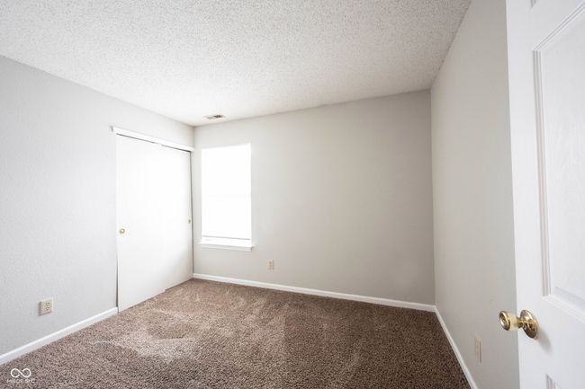 unfurnished room featuring carpet floors, a textured ceiling, visible vents, and baseboards | Image 38