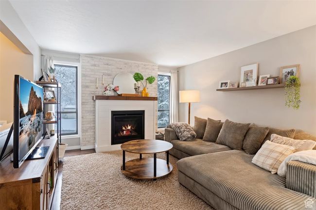 Living room with a brick fireplace and wood finished floors | Image 12