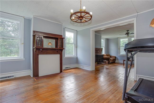 Spacious with large windows, baseboards, crown molding, light wood-style floors, ceiling fan with chandelier | Image 8