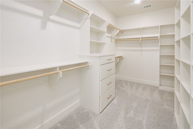 Walk in closet featuring light colored carpet | Image 22
